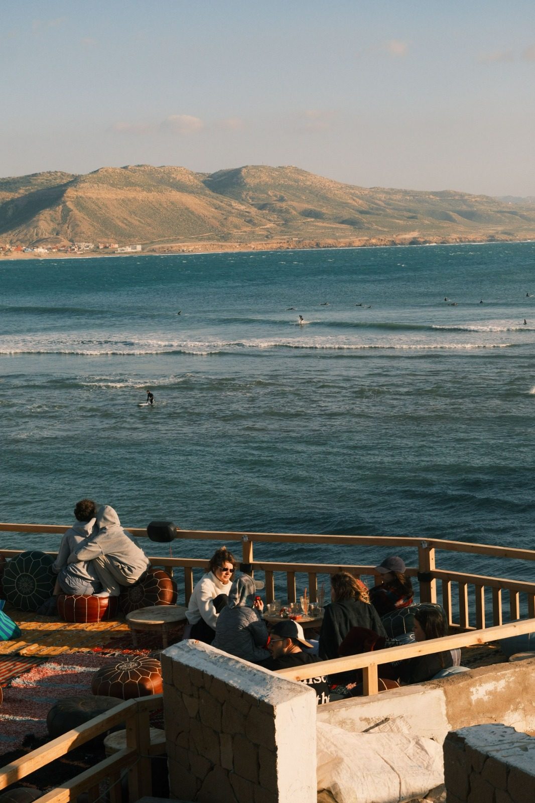 Surfers watching the lineup from a clifftop café in Tamraght